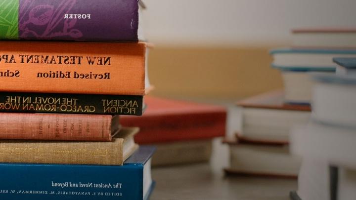 Books from several 纪律s stacked in a pile.