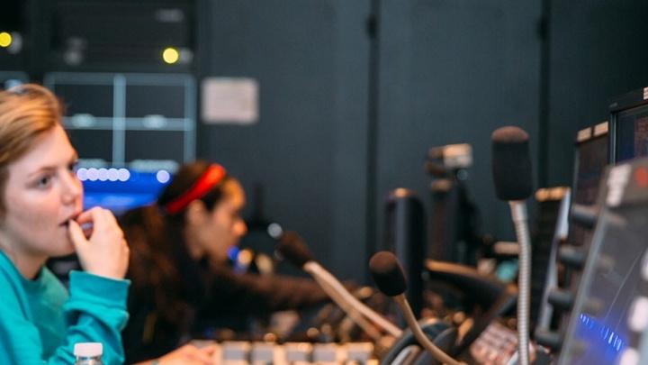 Three female students work the communications console at 赌博娱乐平台网址大全's newsroom, TigerTV