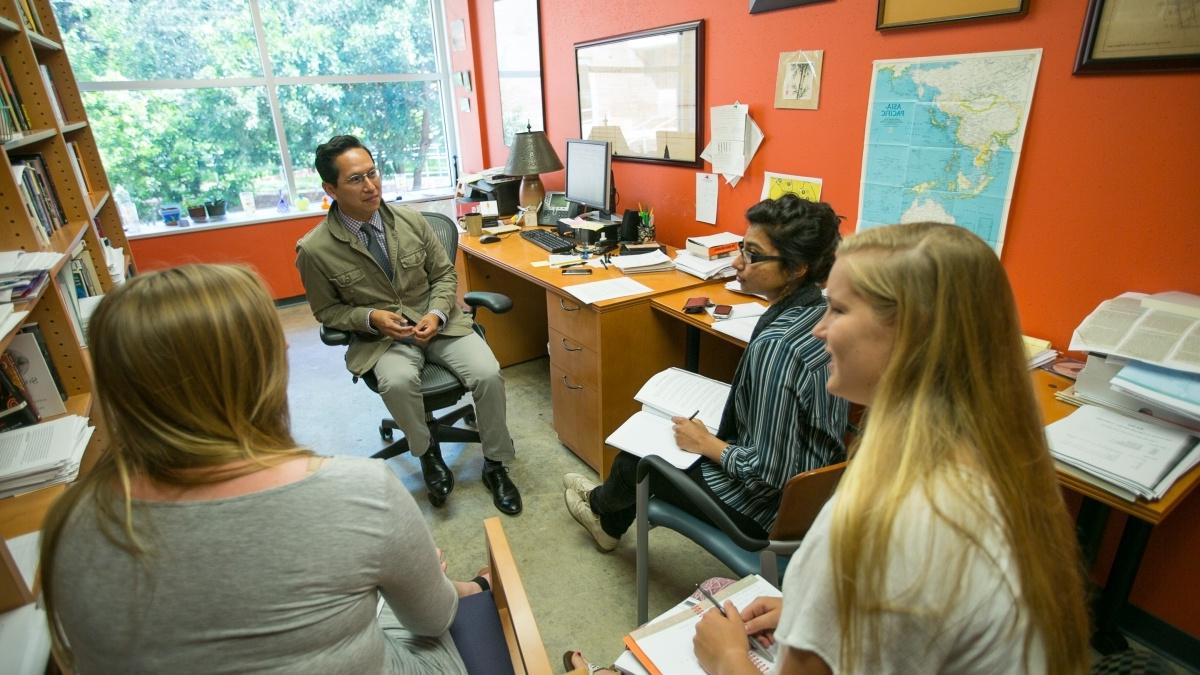 Students gathered around Professor participating in a groupdiscussion